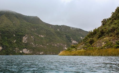 Scenic view of lake by mountains against sky