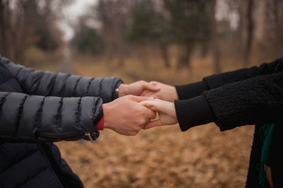 Midsection of couple hands on land during winter