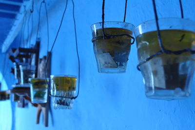 Close-up of water hanging from blue container