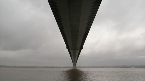 Low angle view of bridge against cloudy sky