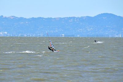 Man surfing on sea against sky