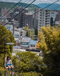 High angle view of girl amidst plants and buildings in city