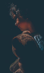 Portrait of young man against black background