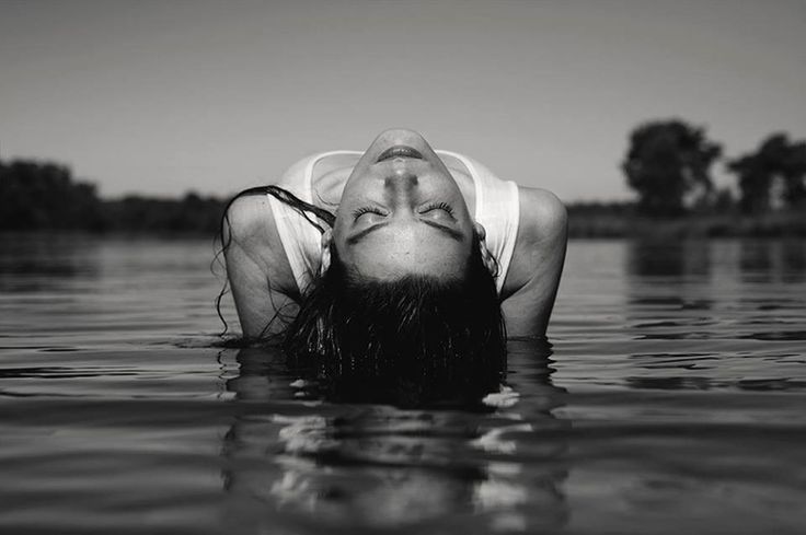 PORTRAIT OF MAN IN SWIMMING POOL AGAINST LAKE