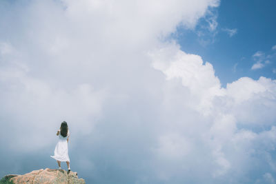 Low angle view of woman standing against sky