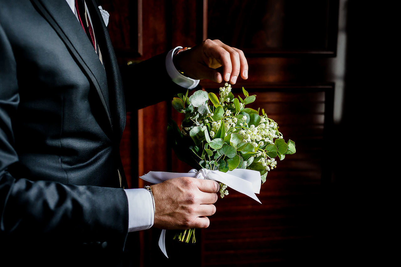 adult, men, business, plant, holding, one person, flower, formal wear, hand, flowering plant, indoors, flower arrangement, bouquet, ceremony, nature, floristry, midsection, clothing, person, businessman, freshness, emotion, standing