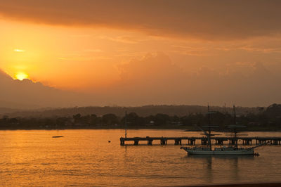 Silhouette of boats in river during sunset