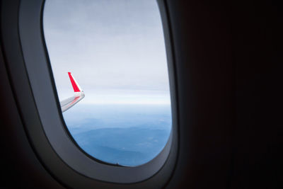 Airplane flying over landscape seen through window