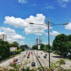 Cars on street in city against sky