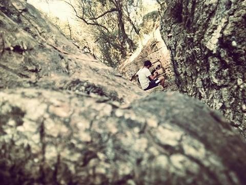 YOUNG WOMAN LEANING ON TREE TRUNK