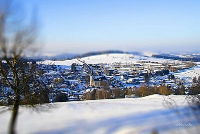 Snow covered landscape against blue sky