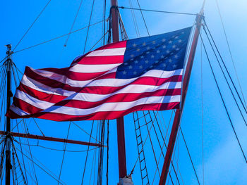 Low angle view of flag against blue sky