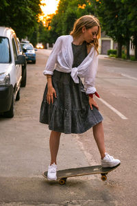 Full length of woman with umbrella standing on street