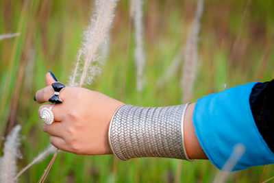 Midsection of woman holding umbrella on field