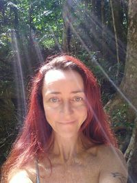 Portrait of smiling young woman in forest