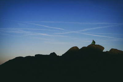 Low angle view of silhouette man against sky