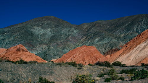 Low angle view of rocky mountains against clear sky