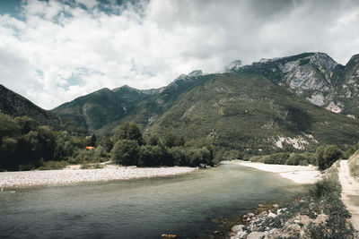 Scenic view of lake by mountains against sky