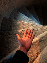 High angle view of person hand on rock