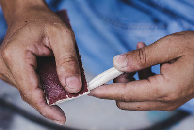 Midsection of man polishing wooden equipment