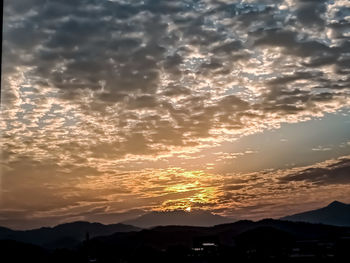 Scenic view of silhouette mountains against romantic sky at sunset