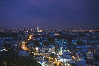 Illuminated cityscape against sky at night