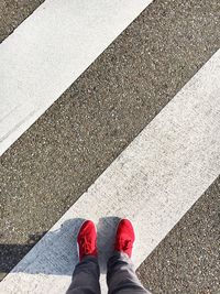 Low section of man standing on zebra crossing