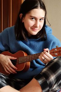 Portrait of woman playing guitar