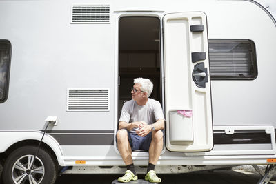 Man sitting at caravan door