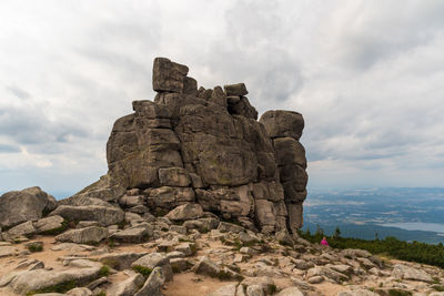 Low angle view of rock formation against cloudy sky