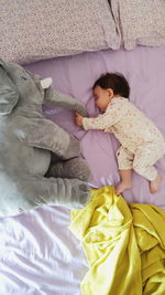 High angle view of baby girl sleeping with toy on bed at home