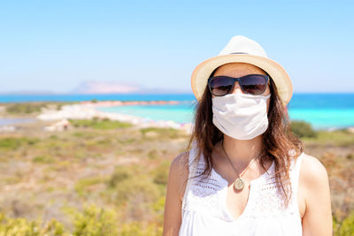 Portrait of young woman wearing sunglasses on beach