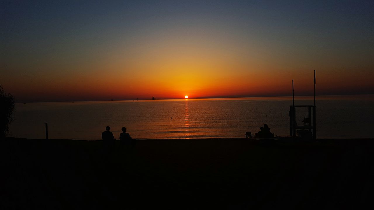 sunset, silhouette, water, sea, sun, orange color, horizon over water, scenics, beauty in nature, tranquil scene, leisure activity, tranquility, nature, idyllic, lifestyles, sky, medium group of people, unrecognizable person, outline, outdoors, vacations, remote, ocean, dark