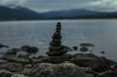 Stack of pebbles on shore against sea