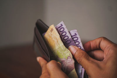 Cropped hand of person holding paper currency