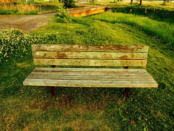 Empty bench on field in park