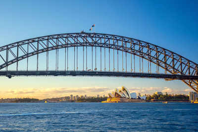 View of suspension bridge over river at sunset