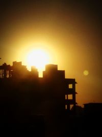 Silhouette buildings against sky during sunset