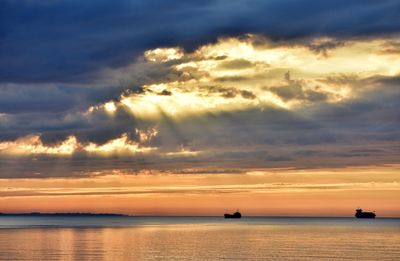 Scenic view of sea against dramatic sky during sunset