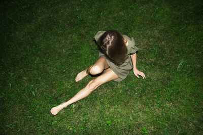 High angle view of baby lying on grassy field