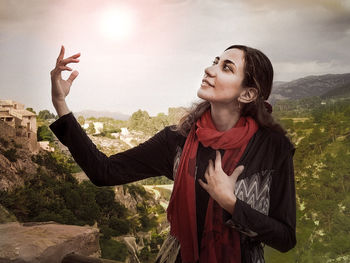 Young woman looking at camera against sky