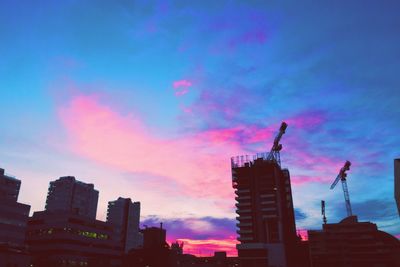 Low angle view of buildings against sky at sunset