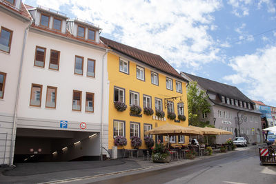 Buildings by street against sky in city