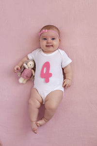 Portrait of cute baby girl sitting on teddy bear