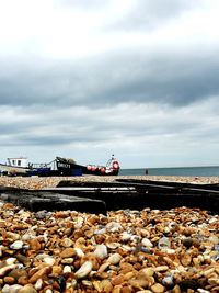 Pebbles on beach against sky