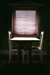 Empty chairs and table in building