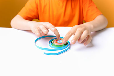 High angle view of man holding multi colored pencils