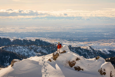 Woman on snowcapped mountain against sky