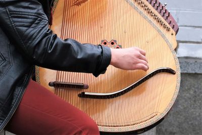 Side view midsection of person playing string instrument