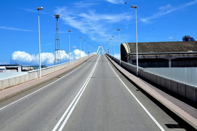 Road leading towards bridge against sky